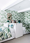 Single beds and wallpaper with leaf motif in the bedroom