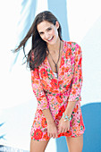 A young woman on a beach wearing a floral dress