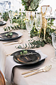 Table festively set for Christmas with eucalyptus branches