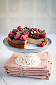 Cheesecake with berries on a cake stand, sliced