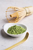 Green matcha tea powder and bamboo whisk