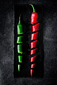 Fresh red and spicy chilli peppers on dark background