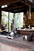 Wasserkocher auf dem Gasherd in rustikaler Küche in Erdfarben