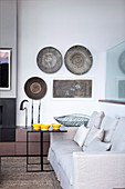 Wall plates and ethnic decorations in the living room in shades of gray