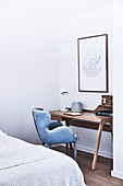 Narrow wooden wall table for the home office with light blue velvet chair in the corner of the bedroom