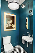 Waschbecken und Toilette in Bad mit dunkelblauen Wänden