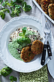 Mixed rice with millet and vegetable patties and lambs lettuce cream sauce (vegan)