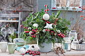 Advent bouquet made of evergreen branches with ornamental apples, ornaments, cones, and a star