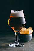 Glass of dark beer and chips