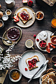 A breakfast table laid with toast, jam, fruits and coffee