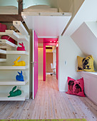 Stairs and shelves leading to gallery in child's bedroom with brightly coloured accessories