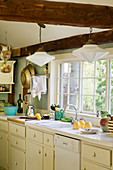 Country-house-style kitchen with wooden beams and lattice window