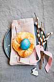 Yeast dough wreath with a blue coloured egg and pussy willow