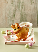 A bread Easter bunny with a cup of coffee and colourful quail's eggs