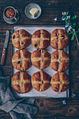 Hot-cross buns with dried cherries on a baking tray