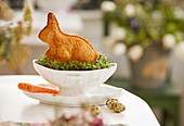 An Easter bunny cake on a bed of cress as a table decoration