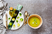 Brussels sprouts vegetable cream soup with spices in bowl and Raw Brussel sprouts