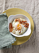Bei Niedrigtemperatur gegartes Ei auf Croûtons mit Käse und knusprigem Speck