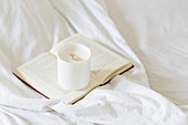 Cafe latte on a book on a bed