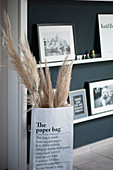 Dry grasses in paper bag in front of narrow shelves