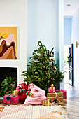 Living room decorated with Christmas tree, colorful Santa bags and wrapped presents