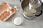 Egg whites and salt being beaten until foamy