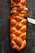 A four-strand bread plait being sliced
