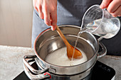 Fondant being mixed and tempered in a bain marie with a sugar syrup