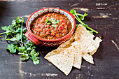 Bowl of fresh, chunky garlic salsa topped with cilantro in Aztec bowl