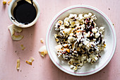 Popcorn drizzled in dark chocolate with shredded and flaked coconut