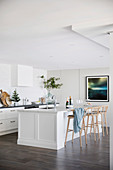 Kitchen island with bar stools in white contemporary kitchen