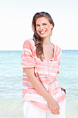 A young woman by the sea wearing a striped blouse