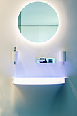 Round mirror with indirect lighting in designer bathroom