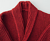 A red, hand-knitted cardigan with a collar