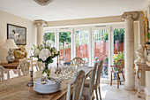 Dining table and terrace doors framed by columns in Neoclassical living room