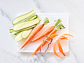 Vegetables being cut into strips with a peeler