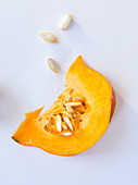 A wedge of pumpkin on a white surface