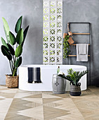 Freestanding bathtub, towel dryer and indoor plants in the bathroom