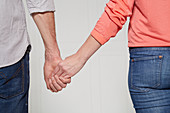 A man and a woman walking hand in hand (body language: 'shyness')