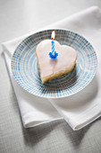 Miniature heart shaped cake with a burning candle