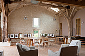 Gallery of artworks and seating area in renovated barn converted into workshop studio