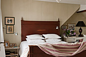 Pillows stacked on wooden bed with quilt