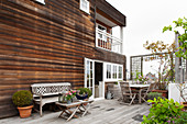 Geräumige Terrasse vor Haus mit Holzfassade