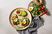 Variety of sandwiches with sliced avocado, sun dried tomatoes, egg, shrimps and arugula