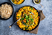 Vegan dal with red lentils, squash, chickpeas and spinach in a bowl with rice on the side (India)