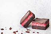 Two pieces of chocolate cherry slice and crumbs