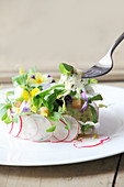 Potato salad spread with sour cream and edible flowers