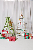 Suspended DIY Christmas tree made from rope and branches, wrapped presents and step ladder