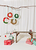 Christmas wreaths handmade from fabric remnants, wooden bench and wrapped Christmas gifts