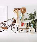 Armchair, side table, indoor palm tree and bicycle